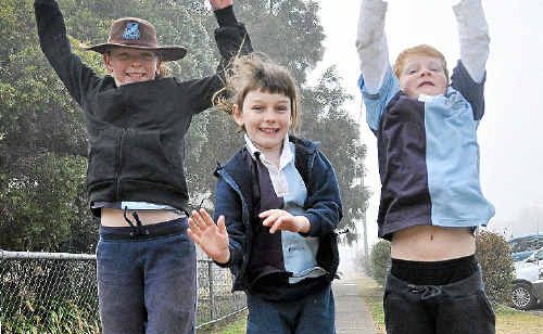 Warwick East School students Romena Hudson, April Hudson and Pierce Johnson warm up during a cold start to school yesterday. Warwick East School students Romena Hudson, April Hudson and Pierce Johnson warm up during a cold start to school yesterday.